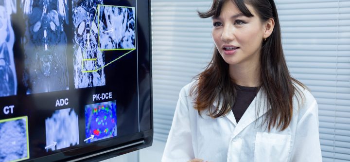 Medicina Nuclear Doctor woman presentation of brain x-ray results through screen to present to medical team in meeting room. Showcases treatment of nervous system and brain.