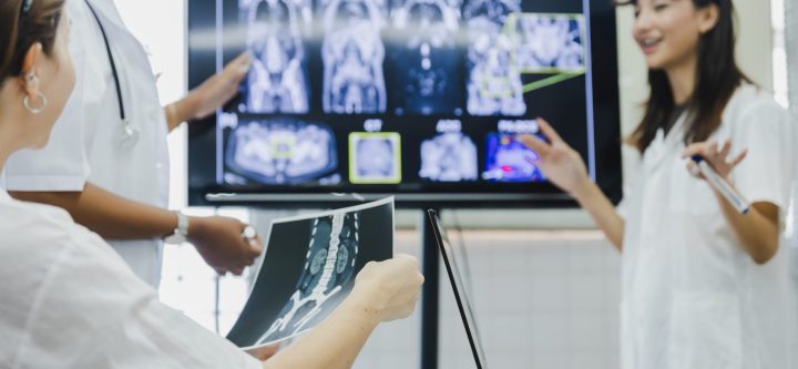 team-of-female-doctor-check-on-scan-results-paper-2026-01-07-06-43-41-utc Team of female doctor check on scan results paper and looking at monitors in laboratory and plan and share medical knowledge and experience benefits her coworkers and patients