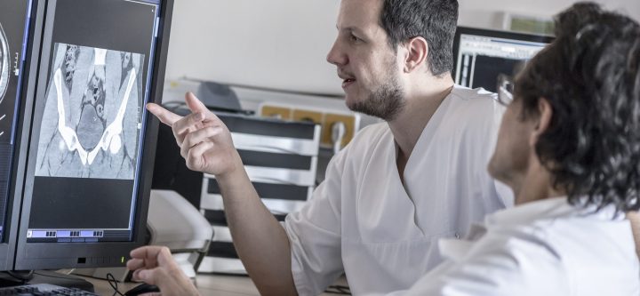 Two doctors discussing x-ray image on computer screen Two doctors discussing x-ray image on computer screen